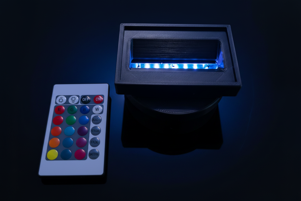 LED base and remote with blue LED glow against navy background — cinematic automotive