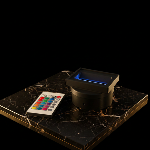 LED base and remote on dark marble with gold accent lighting — elegant luxury presentation